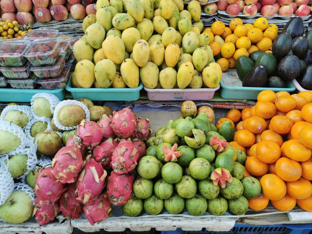 Marché de fruits exotiques - mangues, pitayas, goyaves, oranges et avocats frais