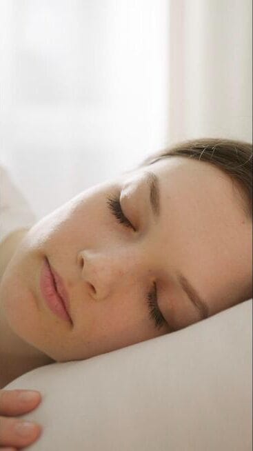 Femme endormie paisiblement, illustrant le sommeil réparateur et le magnétisme
