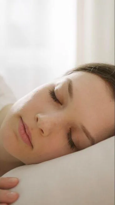 Femme endormie paisiblement, illustrant le sommeil réparateur et le magnétisme